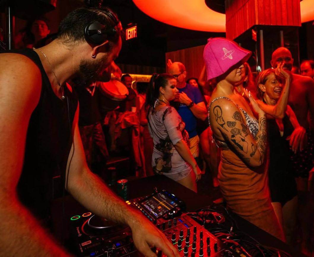 DJs performing in a warm red-lit space